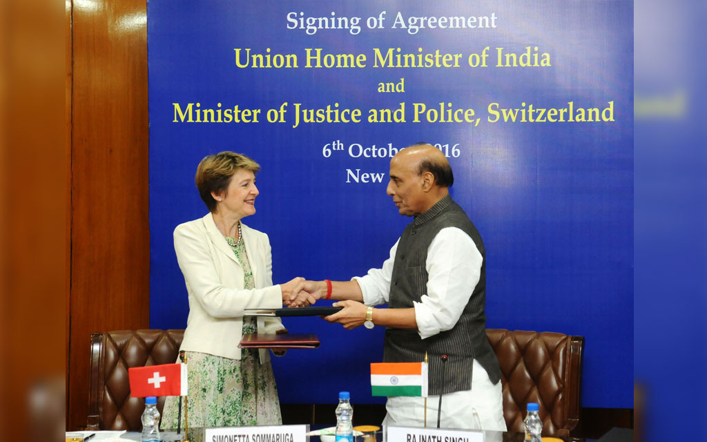 La consigliera federale Simonetta Sommaruga e il ministro indiano degli interni Rajnath Singh si scambiano i documenti dopo aver firmato l‘accordo
